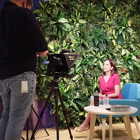 Rashi Kalucha of GroupM doing a video interview in front of a wall of plants